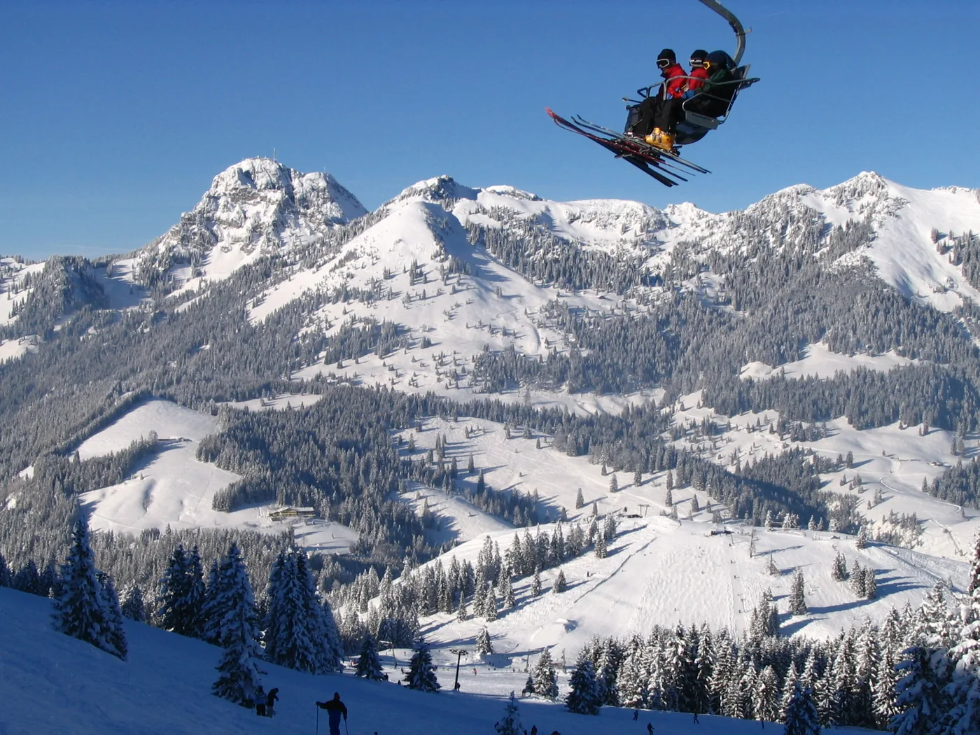 Skigebiet Sudelfeld im Winter &ndash; Sessellift mit Skifahrern und Blick auf den verschneiten Wendelstein